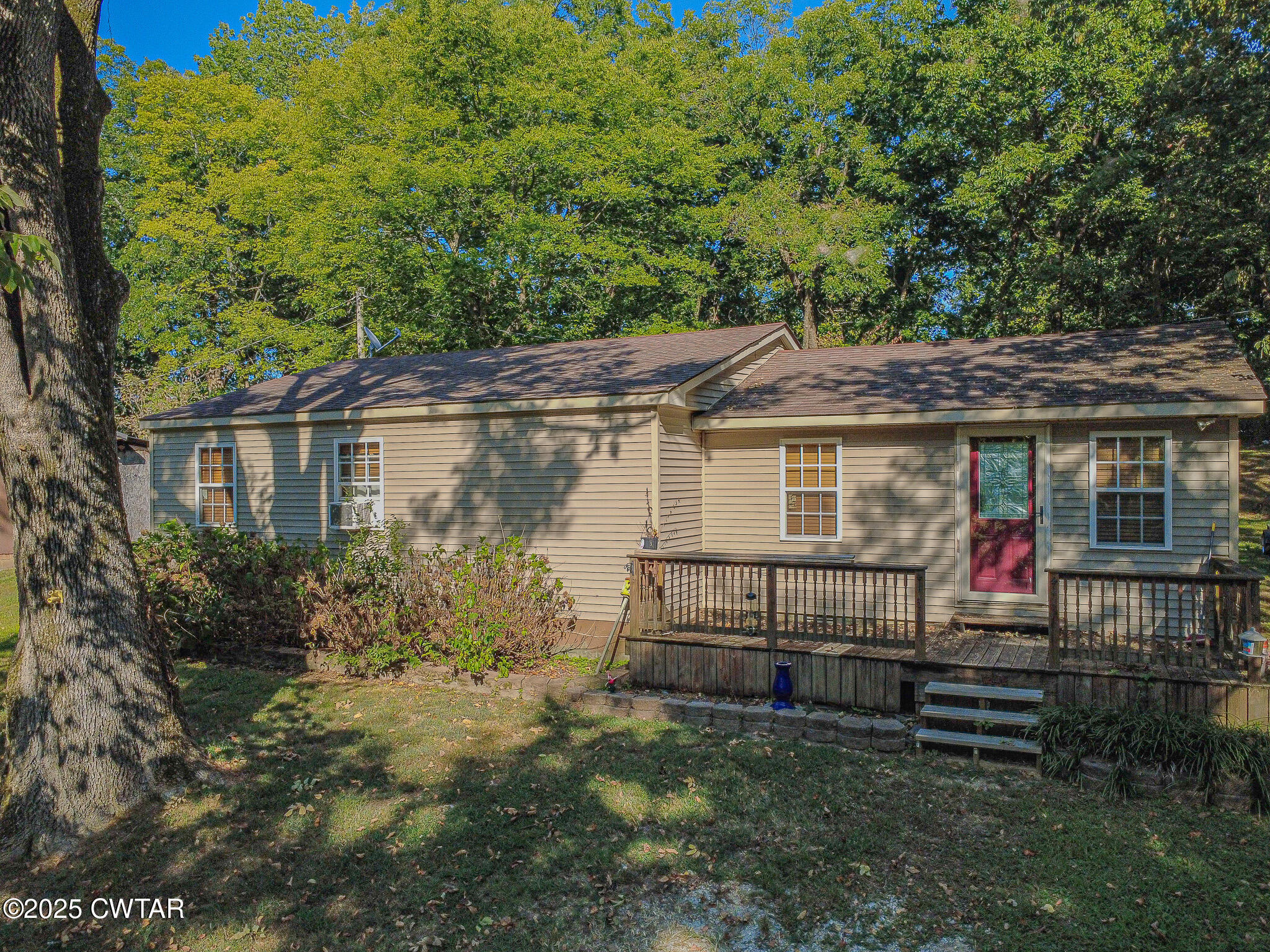 60 Moore Avenue Friendship, TN 38034 - Photo 3 of 14 a view of a house with a small yard plants and large tree
