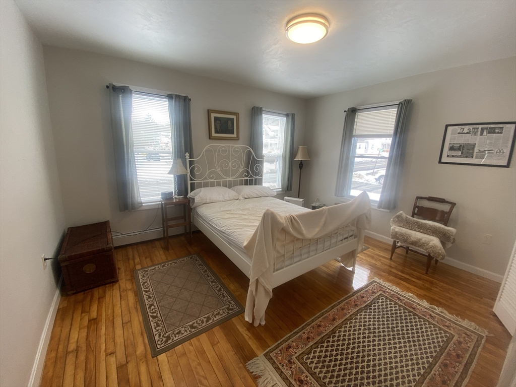 82 Mill Street Worcester, MA 01603 - Photo 14 of 39 a bedroom with a bed and wooden floor