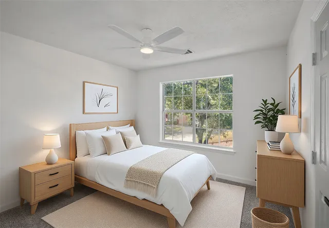 a bedroom with a bed and a large window