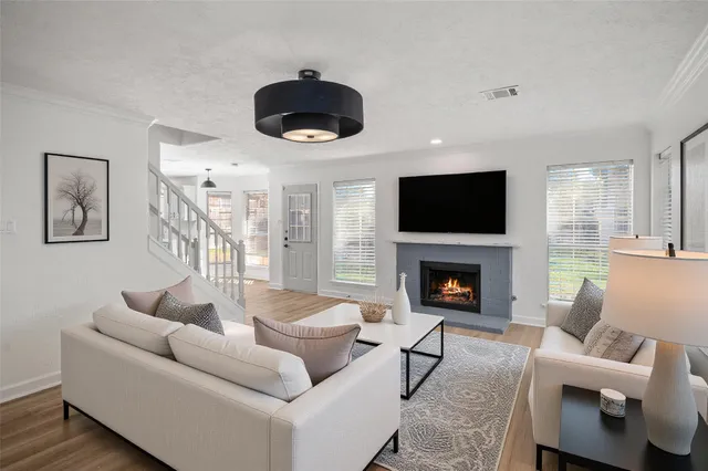 a living room with furniture a fireplace and a flat screen tv