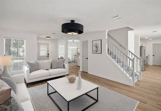a living room with furniture and a wooden floor