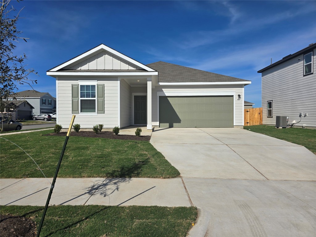 View of front of home with board and batten siding, an attached garage, concrete driveway, and a shingled roof