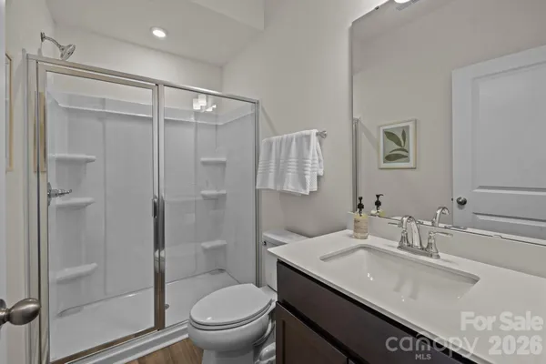a bathroom with a granite countertop sink a toilet and shower