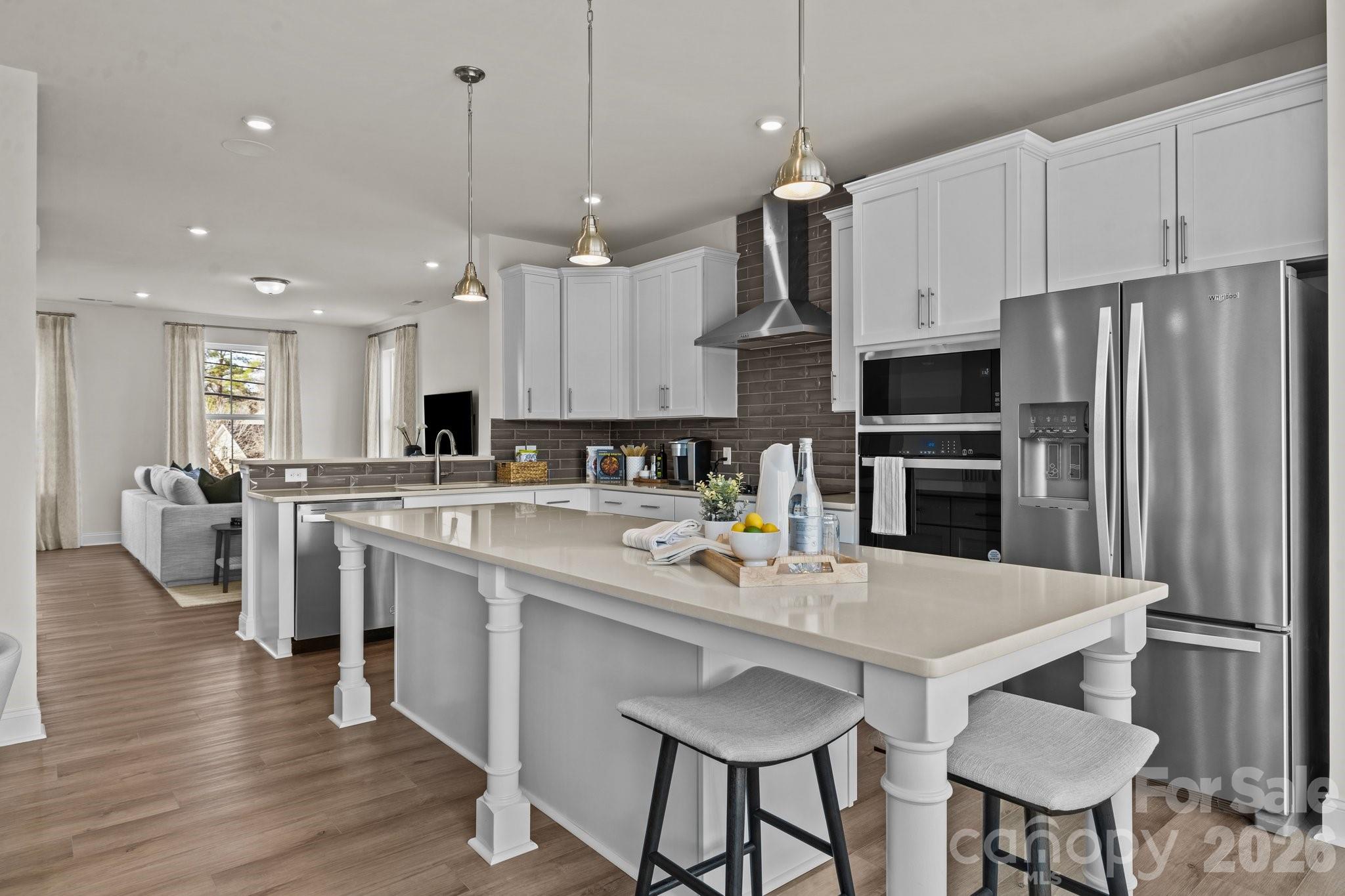 3023 Rozzelles Ferry Road Charlotte, NC 28208 - Photo 6 of 25 a kitchen with stainless steel appliances a table chairs refrigerator and microwave