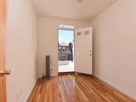 547 83rd Street Brooklyn, NY 11209 - Photo 11 of 12 an empty room with wooden floor and a window