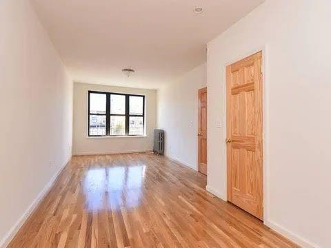 547 83rd Street Brooklyn, NY 11209 - Photo 2 of 12 an empty room with wooden floor and windows