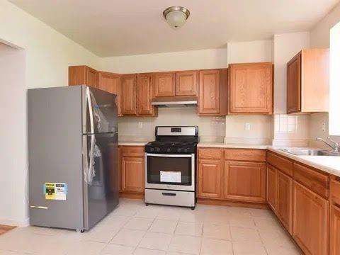 547 83rd Street Brooklyn, NY 11209 - Photo 6 of 12 a kitchen with stainless steel appliances granite countertop a refrigerator sink and stove