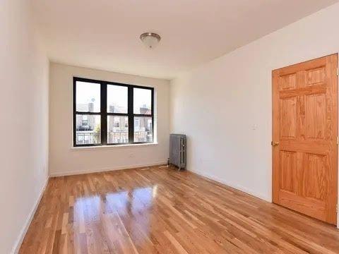 547 83rd Street Brooklyn, NY 11209 - Photo 7 of 12 an empty room with wooden floor and windows