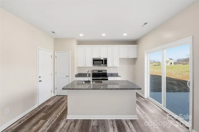 a large kitchen with stainless steel appliances granite countertop a stove and a refrigerator