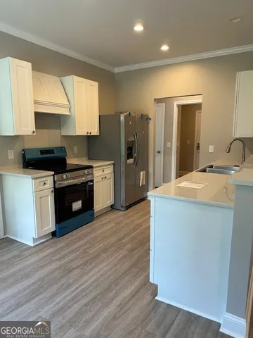 a kitchen with stainless steel appliances a sink wooden floor and a window