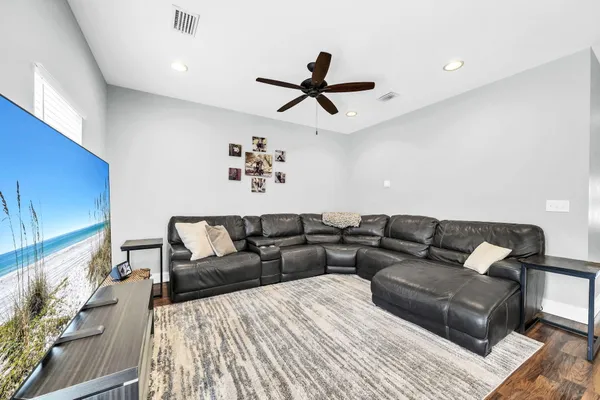 a living room with furniture and a ceiling fan