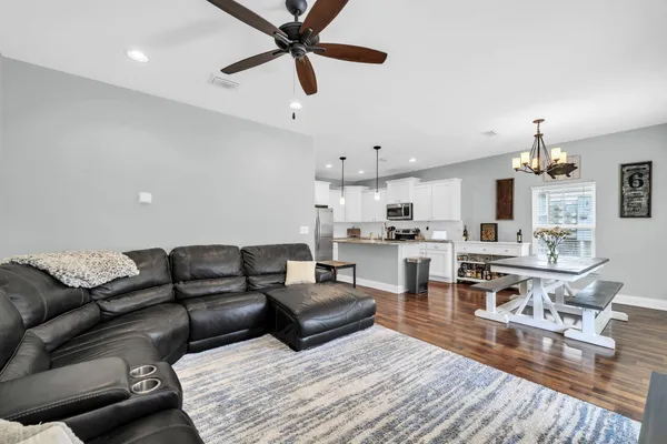 a living room with furniture and a wooden floor