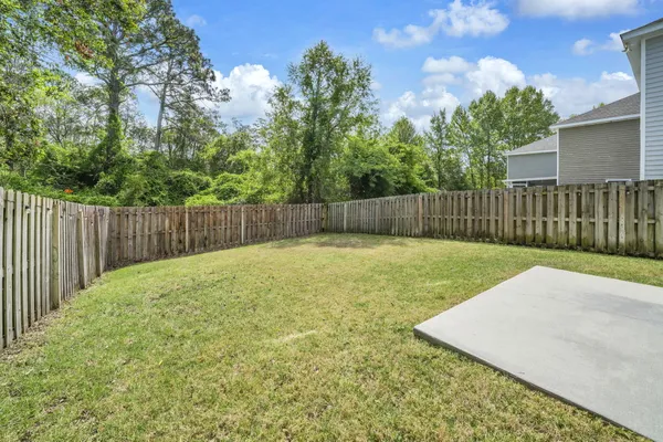 a view of a backyard with a fence and trees