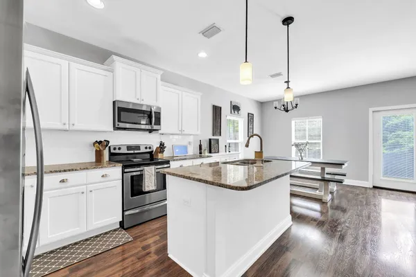 a kitchen with appliances a sink and cabinets