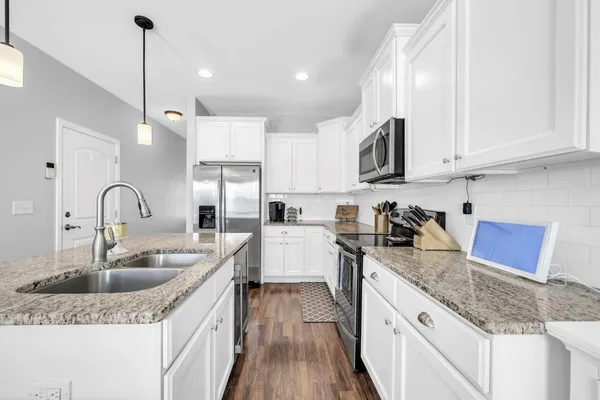 a kitchen with sink a refrigerator and cabinets