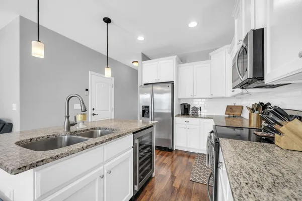 a kitchen with granite countertop a sink a counter top space appliances and cabinets