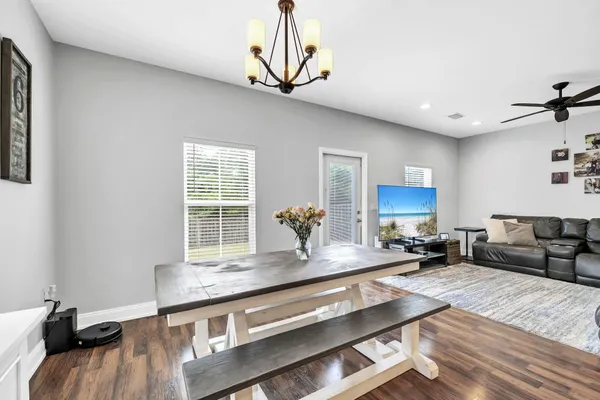 a living room with stainless steel appliances granite countertop furniture a fireplace a flat screen tv and a window