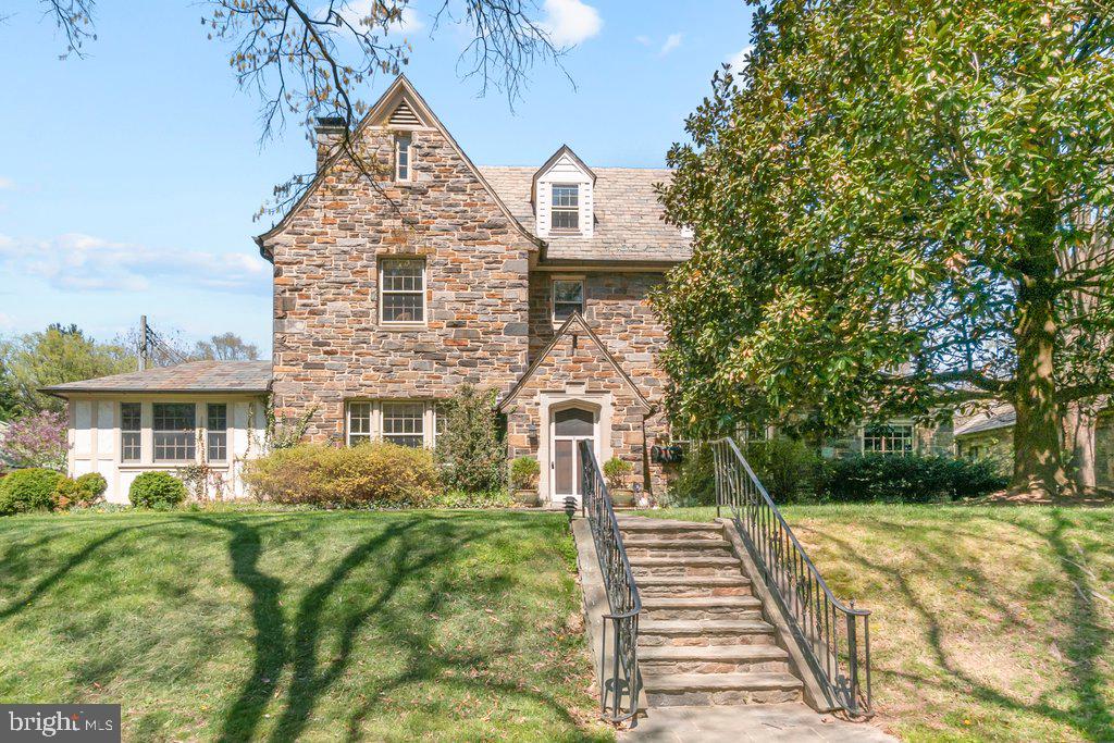 Charming stone residence with lush greenery.