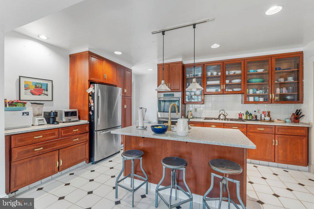 2 East Highfield Road Baltimore, MD 21218 - Photo 16 of 46 a kitchen with stainless steel appliances a dining table chairs refrigerator and sink
