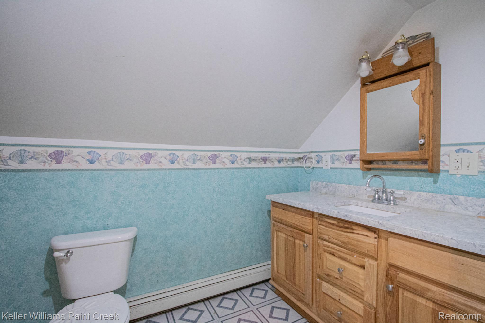 2165 Michigan Road Port Huron, MI 48060 - Photo 25 of 38 Half bathroom featuring a wainscoted wall, vanity, a baseboard heating unit, and vaulted ceiling