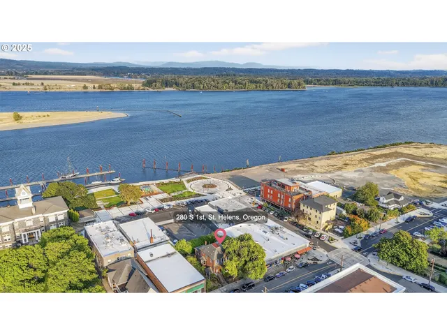 an aerial view of a house with a garden and lake view