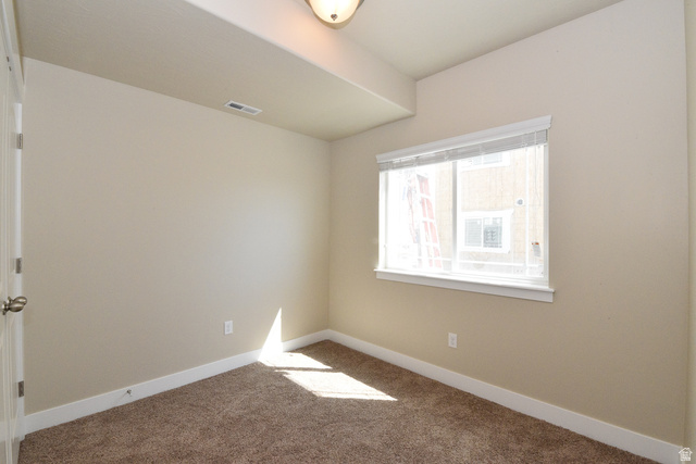 241 West Ridge Road Saratoga Springs, UT 84045 - Photo 16 of 21 Neutral tone wall paint, textured carpet flooring, white window trim, and white baseboards
