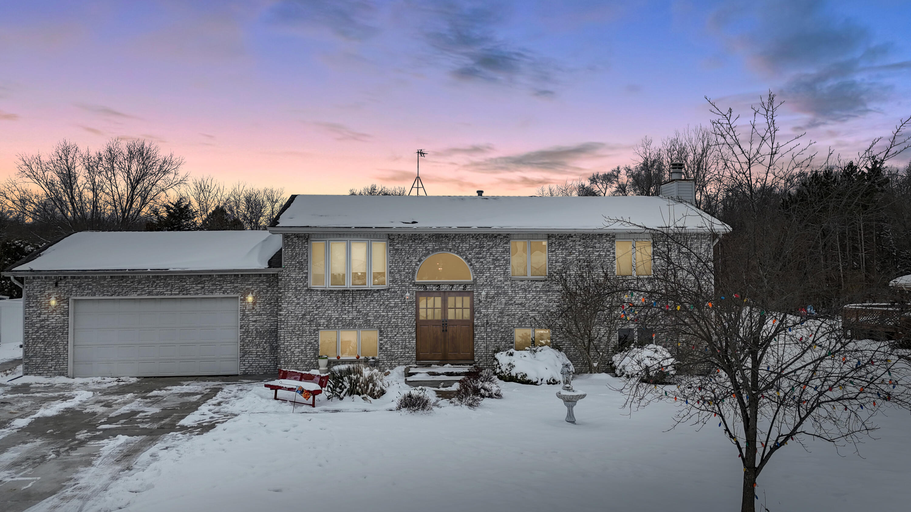 a view of a brick house with large windows and a table and chairs under an umbrella