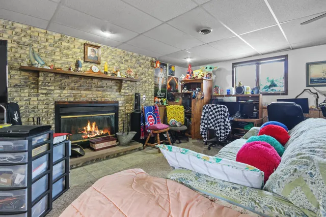 a living room with furniture a fireplace and a floor to ceiling window