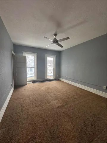 a view of a livingroom with a ceiling fan and window