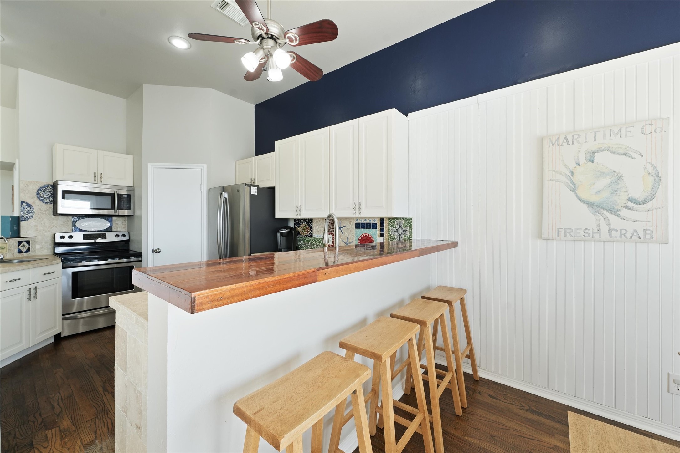 17607 Termini-San Luis Pass Road Galveston, TX 77554 - Photo 11 of 42 A second bar countertop with seating makes this kitchen ideal for hosting and socializing. The classic cabinetry pairs perfectly with the colorful backsplash tiles, adding a coastal charm to the space.