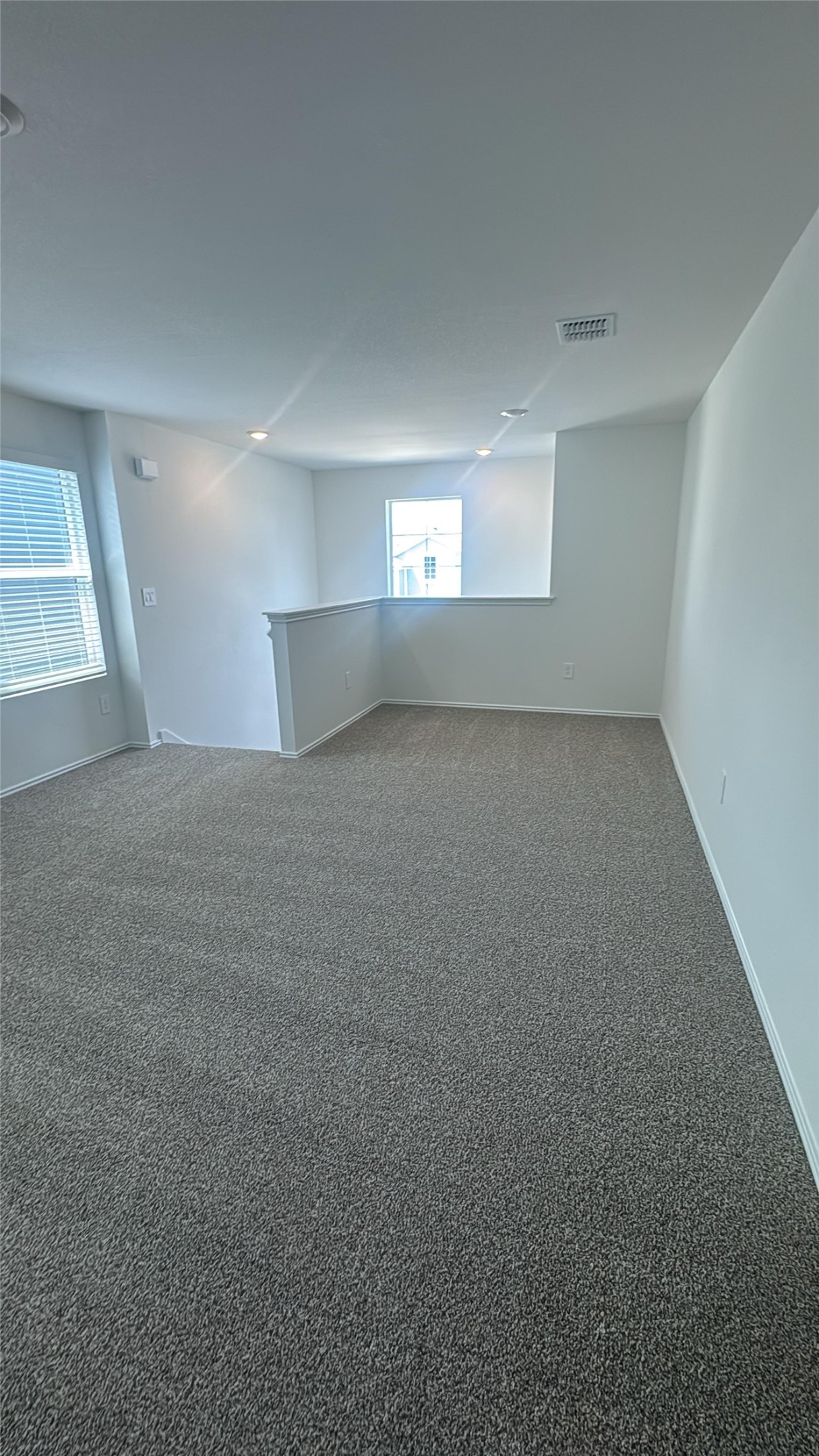 174 Balmorhea Street Kyle, TX 78640 - Photo 11 of 29 A versatile open loft space offers plush carpeted comfort and bright natural light through ample windows.