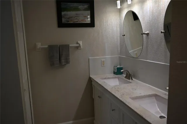 a bathroom with a granite countertop sink a mirror and vanity