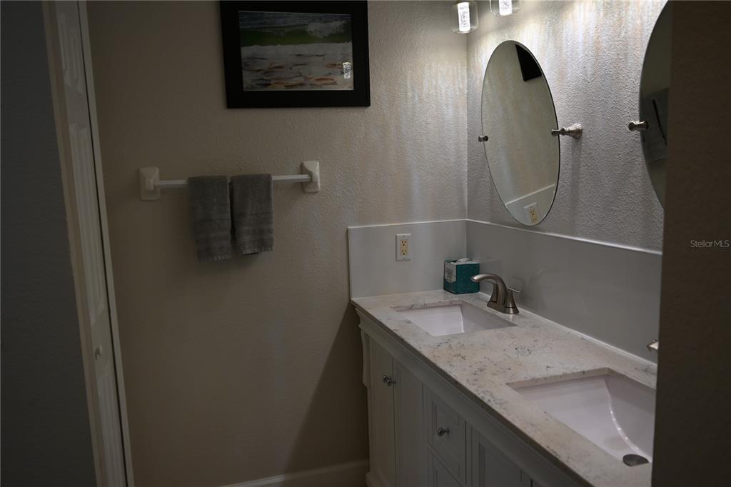 5378 Dunsmuir Road North Port, FL 34288 - Photo 12 of 59 a bathroom with a granite countertop sink a mirror and shower