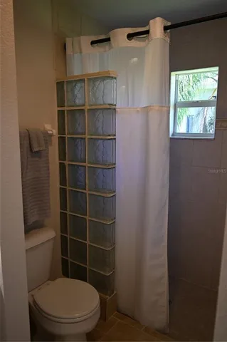 a bathroom with a toilet and a shower