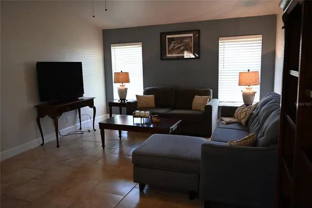 a bedroom with a bed and a flat tv screen on the dresser