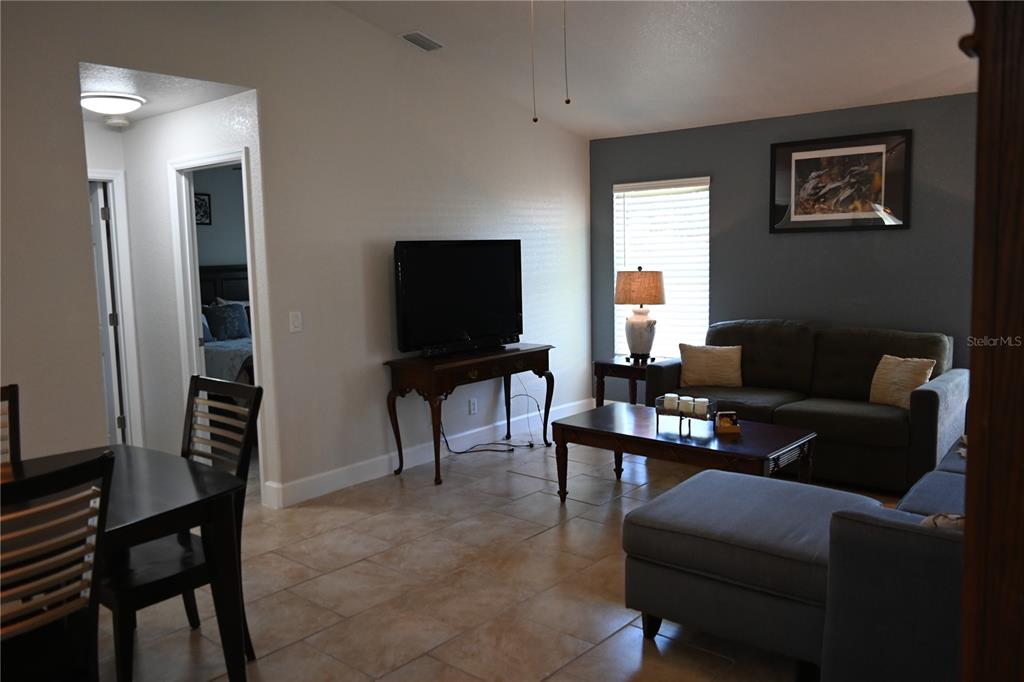 5378 Dunsmuir Road North Port, FL 34288 - Photo 33 of 59 a living room with furniture a piano and a flat screen tv