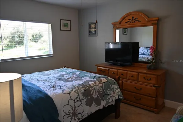 a bedroom with a bed dresser and a mirror