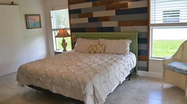 a large white bed sitting in a room next to a window