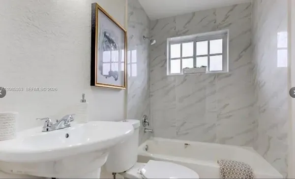a white bath tub sitting next to a white sink