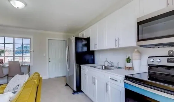 a kitchen with stainless steel appliances a stove a microwave a sink and cabinets