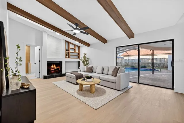 a living room with furniture a fireplace and a large window