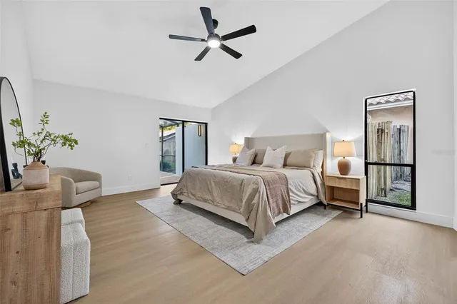 a bedroom with a large bed chandelier and a window