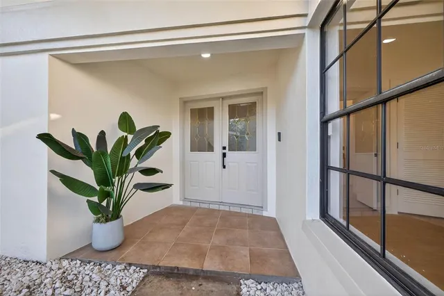 a view of a hallway with wooden floor and a potted plant