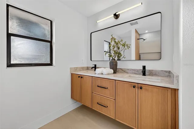 a bathroom with a double vanity sink and a mirror