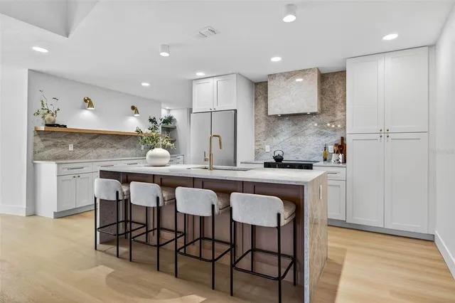 a kitchen with granite countertop white cabinets and chairs