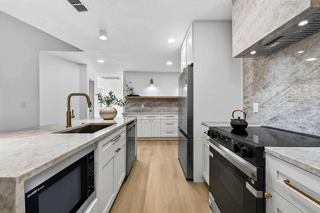 a kitchen with a sink stove and cabinets