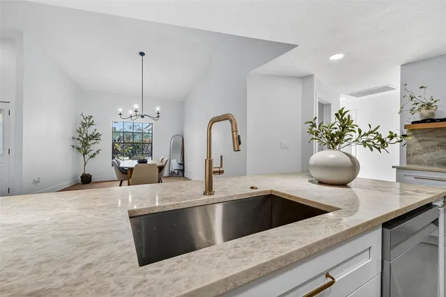 a kitchen with a sink and chandelier