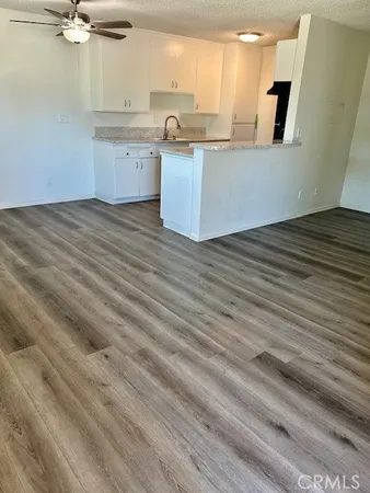 a kitchen with granite countertop a sink cabinets and stainless steel appliances