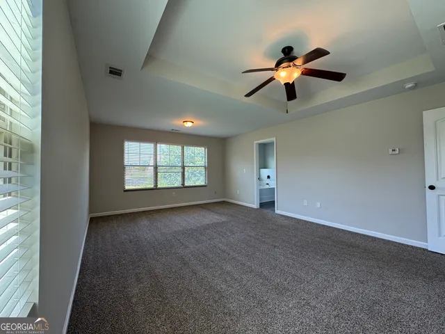 a bathroom with a granite countertop double vanity and a mirror