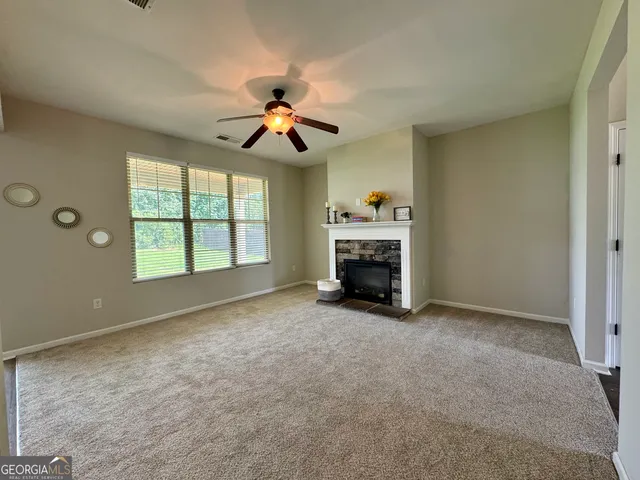 an empty room with windows and ceiling fan